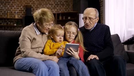 Familia-utilizando-pc-de-la-tableta-en-el-sofá-juntos-en-casa