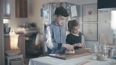 Hermano-y-hermana-pasar-tiempo-en-la-cocina-mientras-hornear-galletas