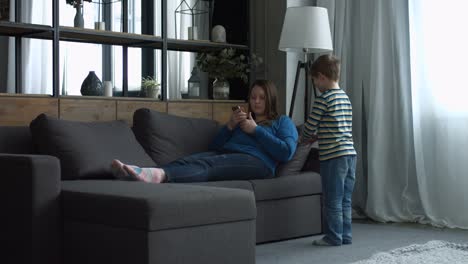 Mother-ignoring-her-little-boy-in-the-bedroom