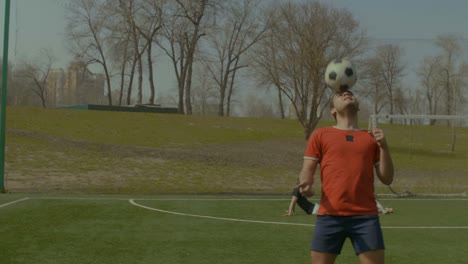 Young-footballer-heading-soccer-ball-on-the-field