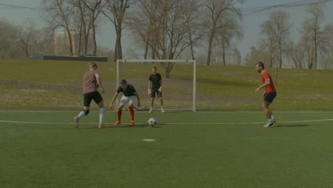 Young-footballer-scoring-a-goal-during-match