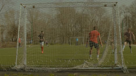 Striker-scoring-a-goal-during-football-training