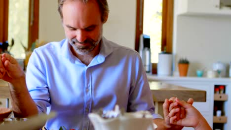 Family-praying-together-before-having-breakfast-in-kitchen-4k