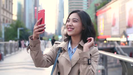 lenta-de-mujer-asiática-joven-muy-feliz-caminando-en-la-calle-durante-el-uso-de-teléfonos-inteligentes-en-la-tarde-de-la-ciudad