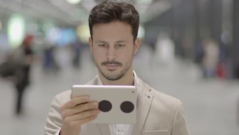 Caucasian-employee-working-online-and-mobile-at-train-station-with-digital-tablet