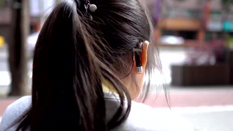 Hearing-loss-child-wearing-a-hearing-aid.At-the-bus-stop.