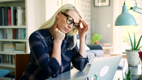 Attraktive-blonde-Geschäftsfrau-Müdigkeit-zu-Hause-Büro