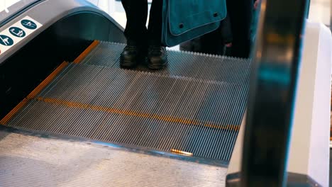 Legs-of-People-Moving-on-an-Escalator-Lift-in-Shopping-Center