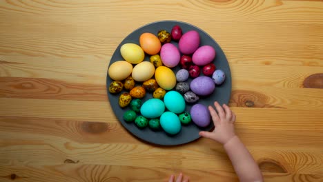 Children-hand-take-colored-Easter-eggs