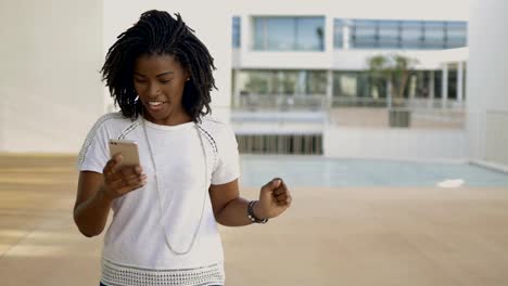 Smiling-young-woman-happy-to-hear-good-news-outdoor.