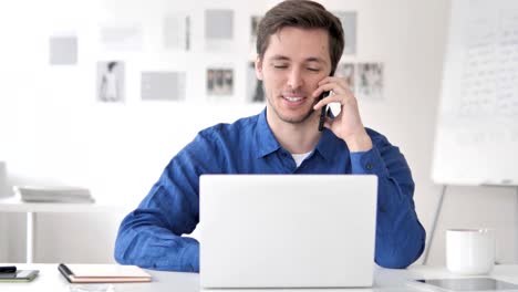 Man-Using-Smartphone-and-Laptop-for-Work