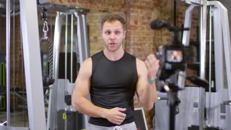 Muscular-Blogger-Showing-Exercise-with-Pulley-Machine-on-Camera