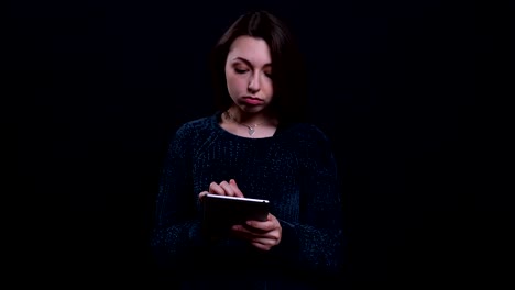 Closeup-portrait-of-adult-beautiful-caucasian-brunette-female-using-the-tablet-with-background-isolated-on-black