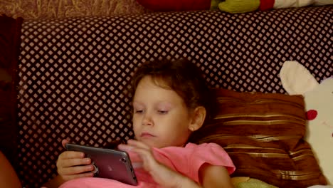 Little-girl-playing-in-game-on-smartphone