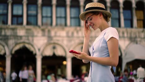 Happy-pretty-hipster-girl-in-hat-using-mobile-phone-and-4G-connection-on-street