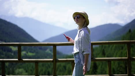 Emocionada-turista-caucásica-usando-conexión-de-red-itinerante-durante-el-viaje-a-las-montañas-haciendo-videollamada