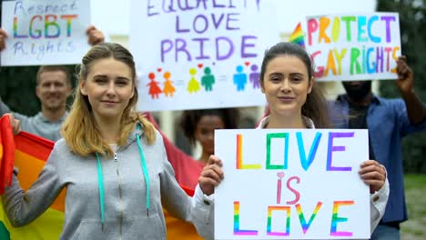 Multitud-positiva-levantando-símbolos-arco-iris-y-carteles-para-los-derechos-LGBT,-marcha-orgullo