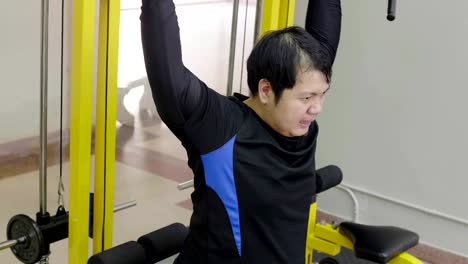 Asian-man-trying-to-exercise-with-dumbbell-in-fitness-gym,-Healthy-lifestyle,-weight-loss-desire