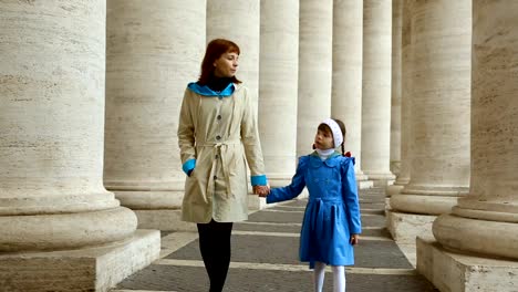 Mujer-con-su-hija-caminando-entre-columnas-en-Piazza-San-Pietro,-Vaticano