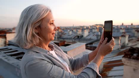 Grey-haired-Female-Tourist-Shooting-Video-on-Roof