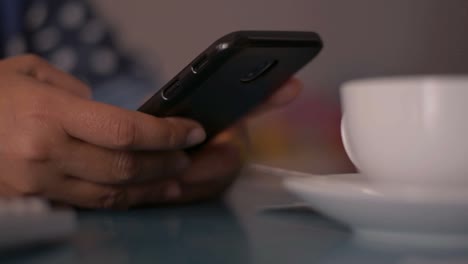 Woman-using-smart-phone-on-the-desk-at-home.