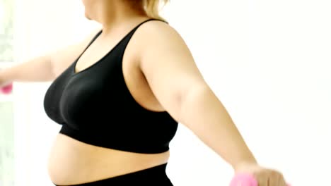 Overweight-young-woman-in-sportswear-exercising-to-lose-weight-at-home