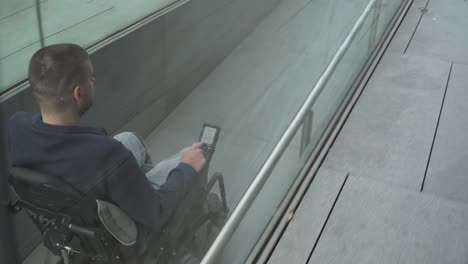 4k-resolution-follow-of-a-man-on-electric-wheelchair-using-a-ramp.-Accessibility-concept