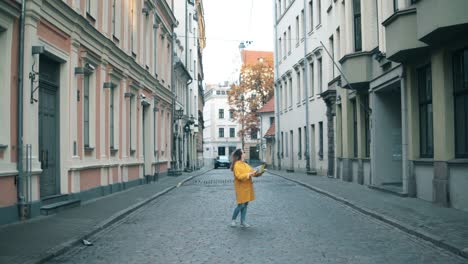 Female-tourist-looks-at-a-map-while-standing-on-a-street.