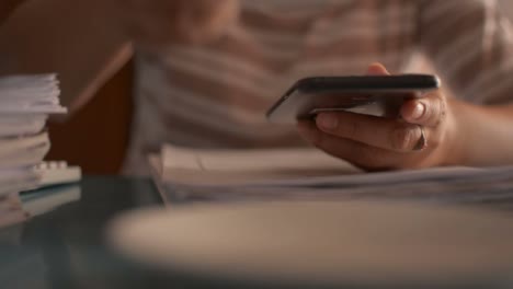 Businesswoman-using-smart-phone-on-the-working-desk-and-drinking-a-cup-of-coffee.