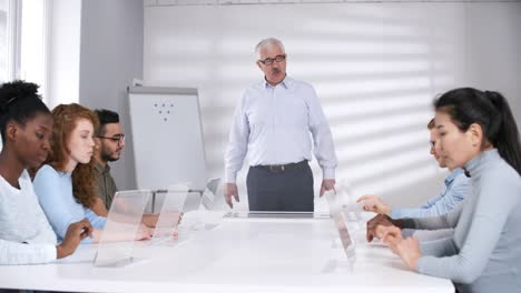 Senior-Male-Teacher-Instructing-Students-in-Futuristic-Classroom