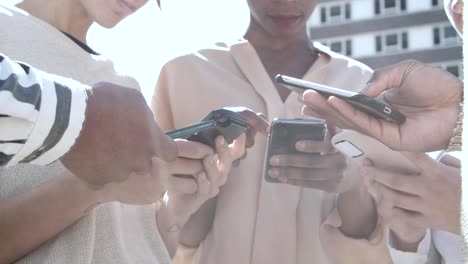 Low-Winkel-Ansicht-von-jungen-Menschen-mit-Smartphones