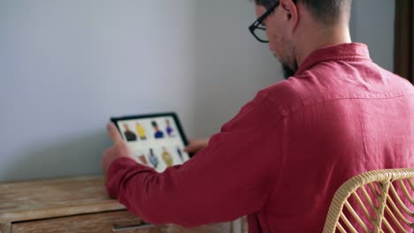 Joven-hombre-está-comprando-ropa-de-la-tienda-en-línea-usando-tableta