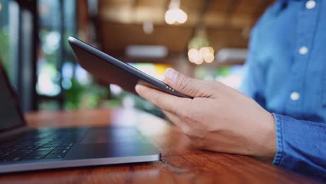 A-young-businessman-wearing-a-surgical-mask-is-doing-a-video-conference-with-customers-via-a-tablet-that-is-connected-to-the-Internet