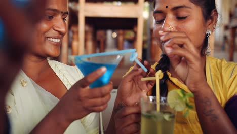 Dos-mujeres-que-beben-bebidas-usando-tecnología-en-café