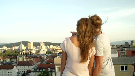 CLOSE-UP:-Novio-mostrando-novia-la-ciudad-apuntando-en-la-azotea-sobre-la-ciudad