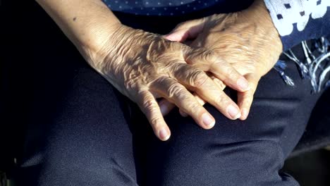 Elderly-woman-hand-on-wheelchair.