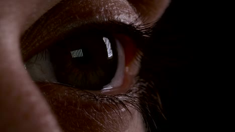 Macro-of-young-man-eye-blinking-in-the-dark