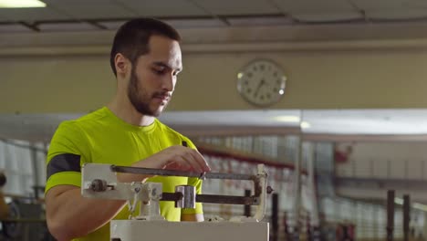 Sportsman-Weighting-Himself-on-Gym-Scale