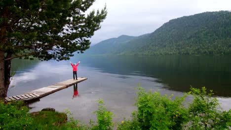 The-girl-in-the-red-jacket-is-standing-on-the-pier-In-virtual-reality-glasses