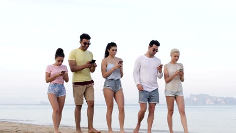 Menschen-zu-Fuß-am-Strand-mit-Smart-Phones,-junge-Touristen-Zellgruppe-Networking-Online