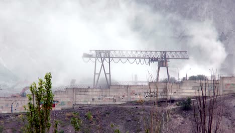 Grúa-de-pórtico-en-medio-del-polvo-y-humo