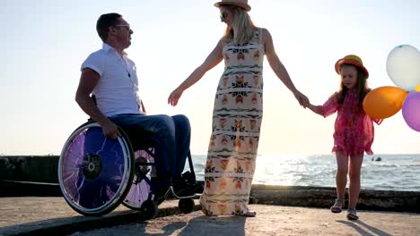 disabled-man-in-wheelchair-with-daughter-and-wife-on-background-blue-sky