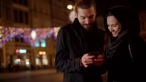 Junge-Brautpaar-mit-Smartphone-in-der-Nacht.