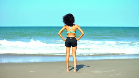 Afroamerikanische-Frau-dabei-stretching-Training-vom-Ozean