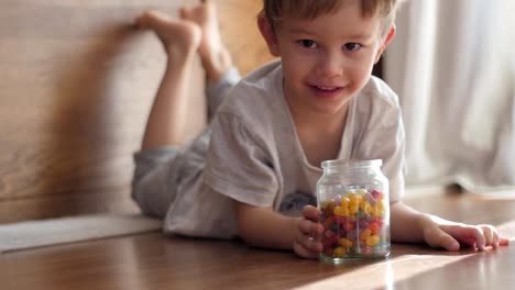 Jungen-spielen-mit-Glas-mit-Süßigkeiten