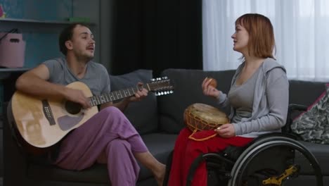 Hombre-alegre-interpretando-la-canción-en-casa-y-mujer-parapléjico