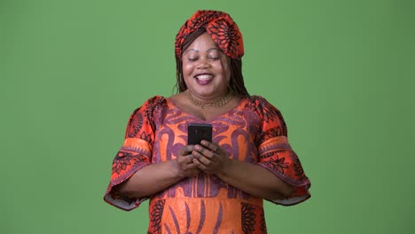 Overweight-beautiful-African-woman-wearing-traditional-clothing-against-green-background