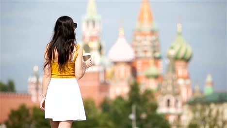 Happy-young-urban-woman-drinking-coffee-in-european-city.