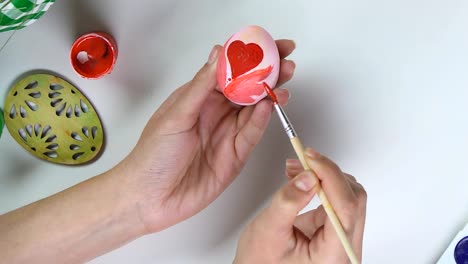 Woman-painting-red-patterns-on-egg-with-brush,-handmade-decoration,-creativity