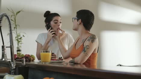 Las-mujeres-homosexuales-chicas-socios-comer-fruta-y-hablando-en-el-teléfono